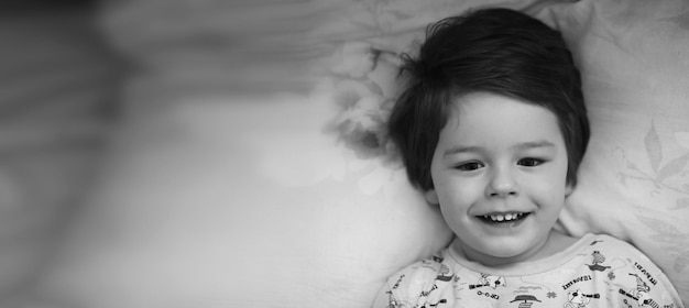 Zwart-wit foto portret van een jong kind liggend op kussen