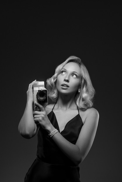 Zwart-wit portret van een vrouw met camera in oude Hollywood-glamourstijl