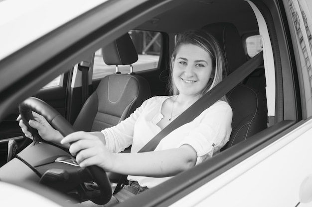 Zwart-wit portret van lachende vrouw rijdende auto