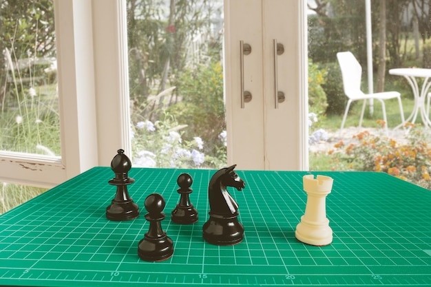 Zwart-wit schaakgevecht op groen bord, schaakoverwinning, bedrijfsconcept.