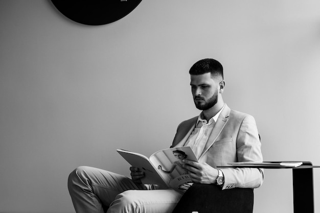 Zwart-wit zakenman leest tijdschrift in hotel