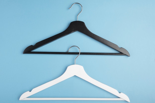 Zwart-witte hangers met elkaar verbonden op blauw. Concept weergave.