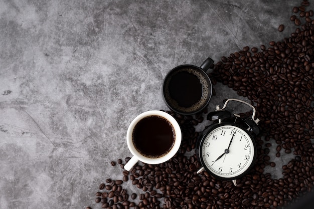 Zwart-witte koffiemokken op de achtergrond van de cementtextuur. 's ochtends koffie concept, weergave van bovenstaande tabel.