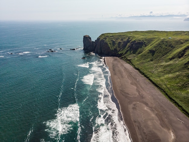 zwart zandstrand van Reynisfjara en de berg Reynisfjall vanaf het voorgebergte Dyrholaey aan de zuidkust van IJsland.