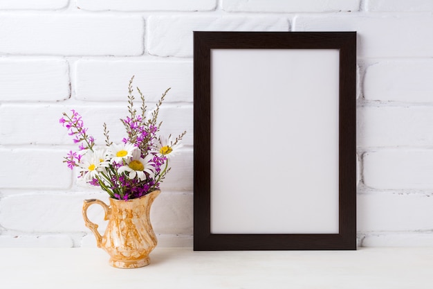 Zwartbruin frame met kamille en paarse bloemen in gouden kan