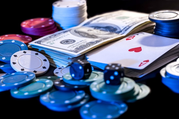 Foto zwarte achtergrond met pokerfiches, kaarten, dollars en botten