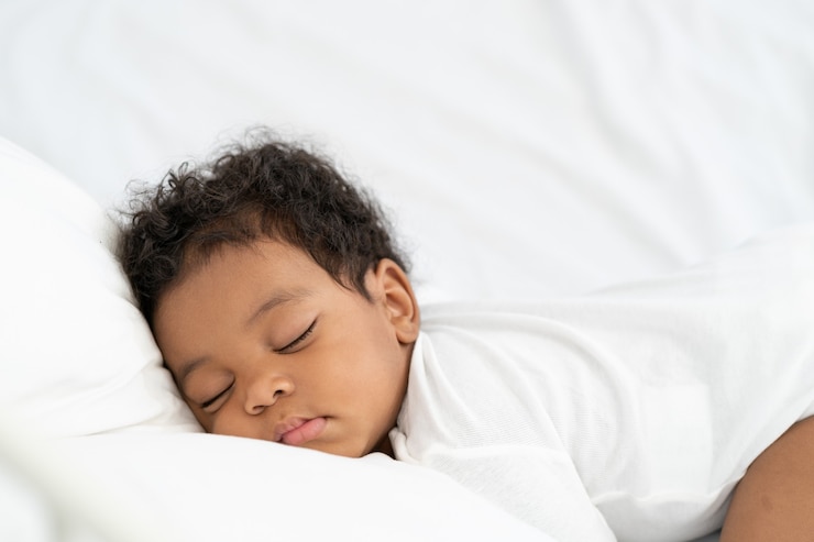 Foto zwarte afrikaanse amerikaanse babyslaap op een witte matras.