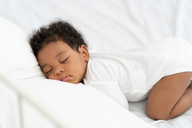 Foto zwarte afrikaanse amerikaanse babyslaap op een witte matras.
