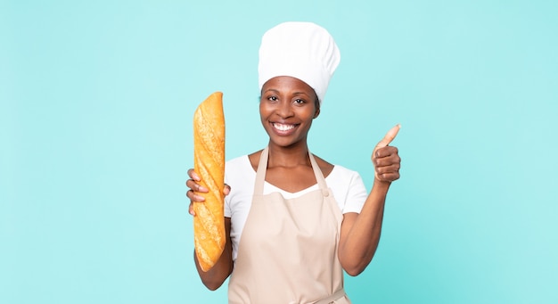 zwarte afro-amerikaanse volwassen chef-kokvrouw met een broodbaguette