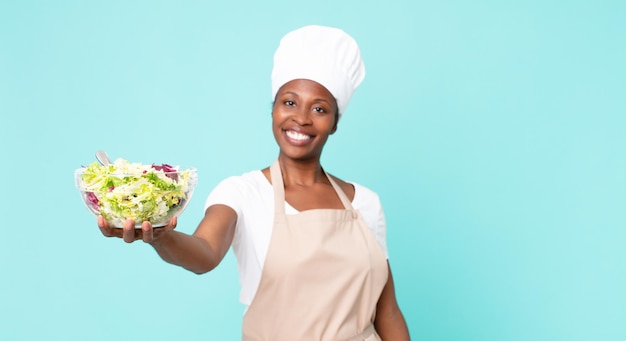 Zwarte Afro-Amerikaanse volwassen chef-kokvrouw met een salade