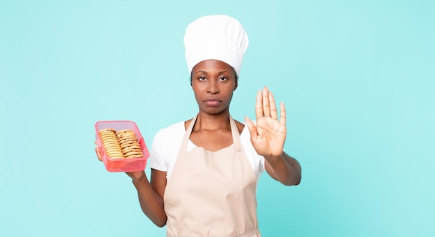 zwarte afro-amerikaanse volwassen chef-kokvrouw met een tupperware