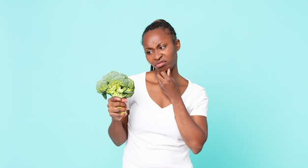 Zwarte afro-amerikaanse volwassen vrouw met een broccoli