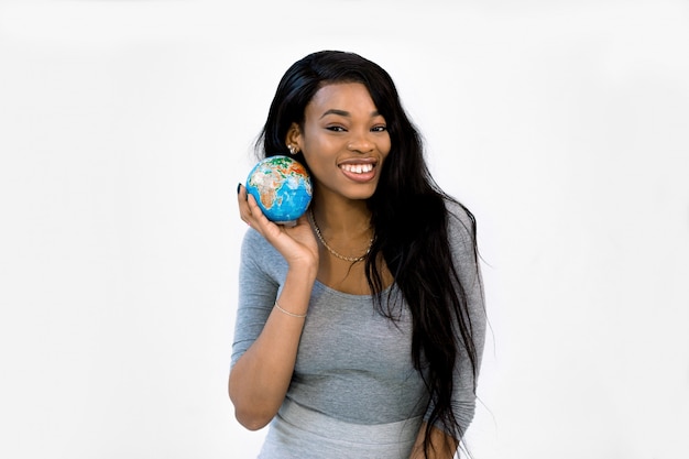 Zwarte Afro-Amerikaanse vrouw houdt een wereldbol in haar handen