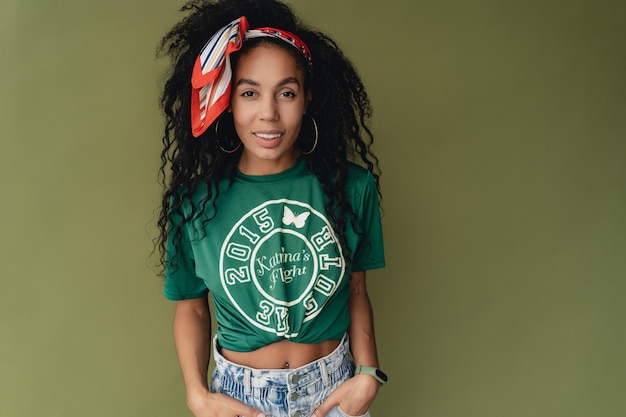 zwarte afro-amerikaanse vrouw in stijlvol hipster-outfit t-shirt en korte broek op groen