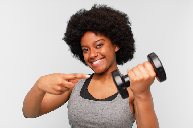 Zwarte afro fitness vrouw met een dumbbell