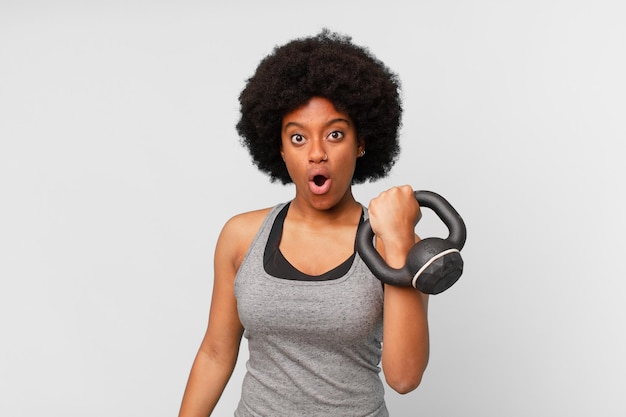 Zwarte afro fitness vrouw met een dumbbell