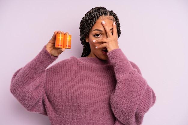 Zwarte afro-vrouw die geschokt, bang of doodsbang kijkt en haar gezicht bedekt met de hand. batterij concept