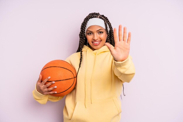 Zwarte afro-vrouw die lacht en er vriendelijk uitziet, met nummer vijf. basketbal concept