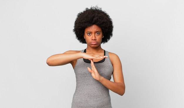 Zwarte afro-vrouw die serieus streng boos en ontevreden kijkt en een time-out tekent