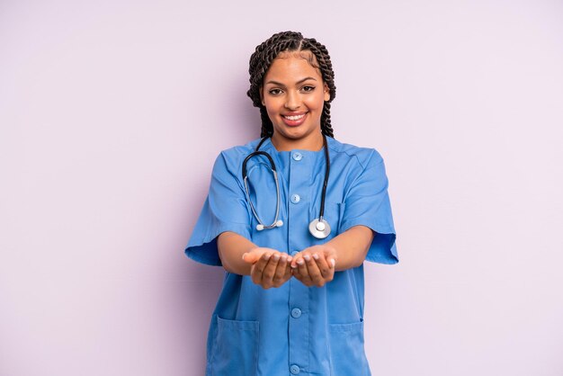 Zwarte afro-vrouw die vrolijk lacht met vriendelijk en een concept aanbiedt en toont. verpleegster concept