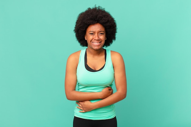 Foto zwarte afro-vrouw die zich angstig, ziek, ziek en ongelukkig voelt, pijnlijke buikpijn of griep heeft