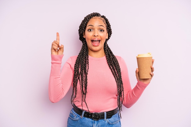 Zwarte afro-vrouw die zich een gelukkig en opgewonden genie voelt na het realiseren van een idee. koffie meenemen