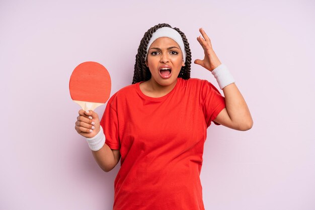 Zwarte afro vrouw schreeuwen met handen omhoog in de lucht ping pong concept