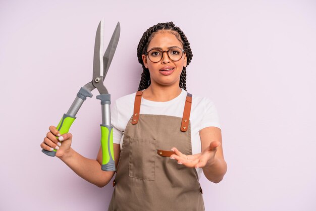 Zwarte afrovrouw die boos, geïrriteerd en gefrustreerd kijkt. tuinman of boer concept