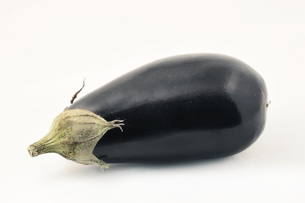 zwarte aubergine liggend op zijn kant op een witte achtergrond