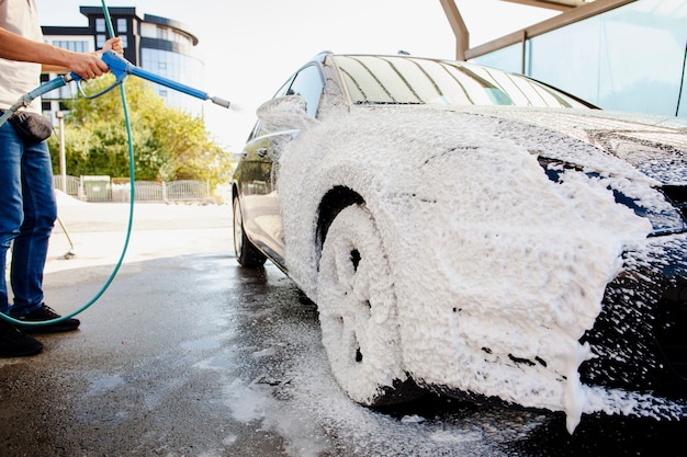 Foto zwarte auto bedekt met zeepschuim