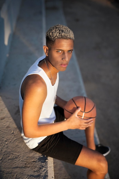 Zwarte basketbalspeler zittend op trappen