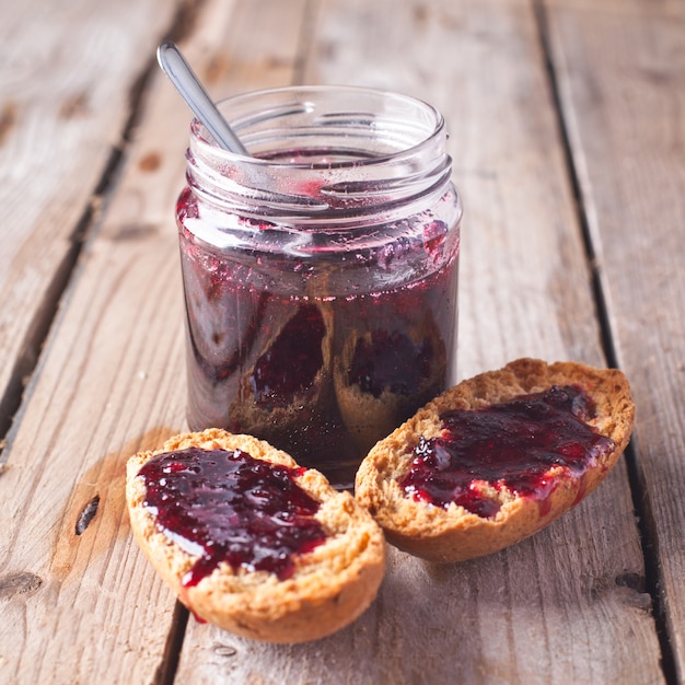 Zwarte bessenjam in glaskruik en crackers