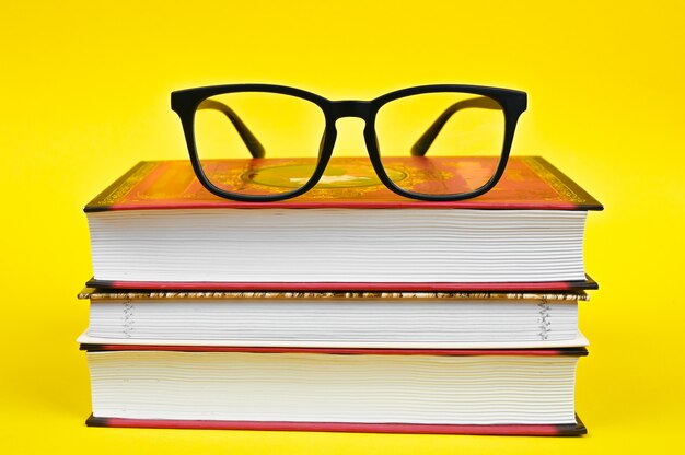 Zwarte bril met stapel boeken
