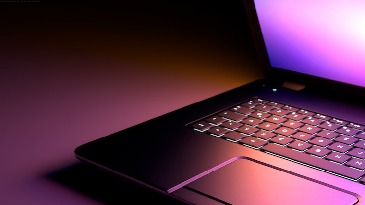 Foto zwarte bureaulaptopcomputer met lichtroze paarse lichtweergave.