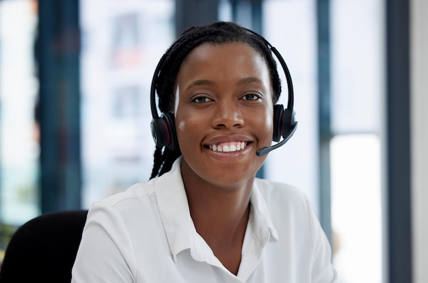 Zwarte callcentermedewerker en glimlach in portretcommunicatie en CRM-headset en headshot Neem contact met ons op klantenservice of telemarketing met verkoop blije vrouwelijke consultant en helpdesk