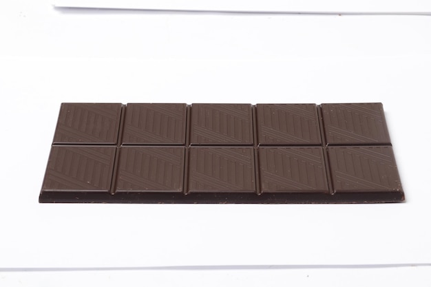 Zwarte chocoladereep geïsoleerd op een witte achtergrond.