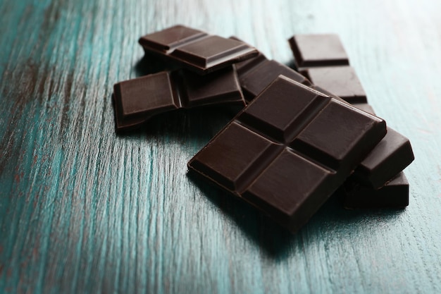 Zwarte chocoladestukjes op een houten achtergrond in kleur