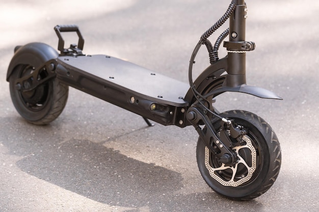 Zwarte elektrische scooter staat op de treeplank op straat