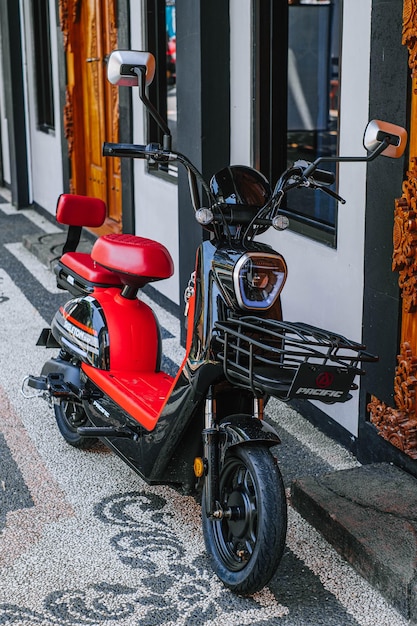 Foto zwarte en rode elektrische fiets met mand ervoor