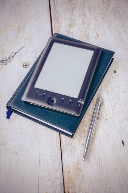 Zwarte ereader met notitieboekje en inktpen