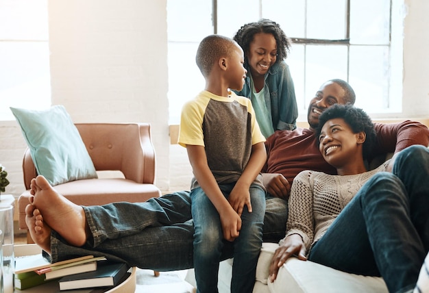 Zwarte familie kinderen gelukkige ouders of ontspannen Afrikaanse mensen glimlachen samen band en genieten van quality time Geluk liefde en jonge jeugd kinderen gemakkelijke vader en moeder lounge op de bank in de woonkamer