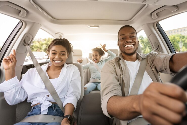 Zwarte familie rijdende auto reizen in de zomer glimlachend naar de camera