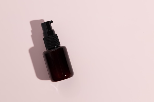 Zwarte fles serum op roze achtergrond Mockup