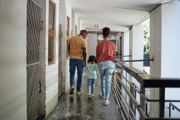 Zwarte gezinskinderen en dierenasiel met een meisjesmoeder en vader die samen op een balkon lopen Kinderenvrijwilliger en liefdadigheidsinstelling met een man vrouw en dochter hand in hand in een opvangcentrum