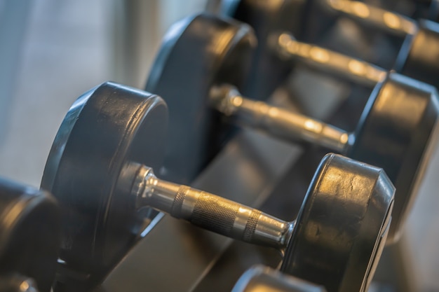 Zwarte halterset close-up van veel metalen halters op rek in sportfitnesscentrum gewichtstraining