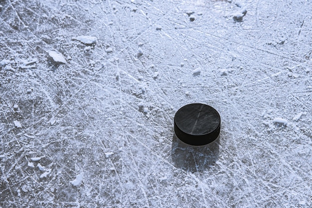 Zwarte hockeypuck ligt op ijs in het stadion