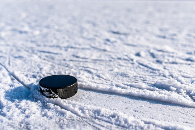 Zwarte hockeypuck ligt op ijs in het stadion