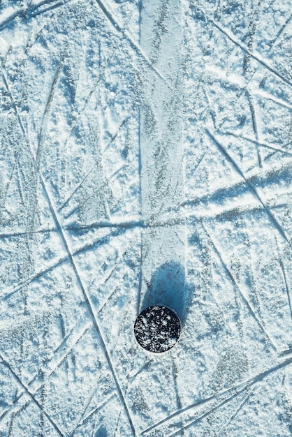 Zwarte hockeypuck ligt op ijs in het stadion