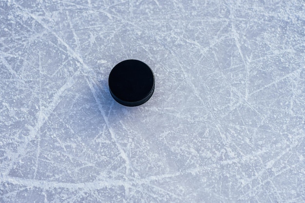 Foto zwarte hockeypuck ligt op ijs in het stadion