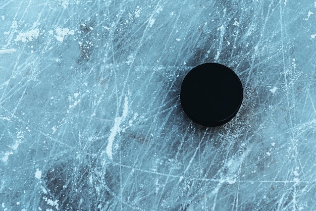 Foto zwarte hockeypuck ligt op ijs in het stadion